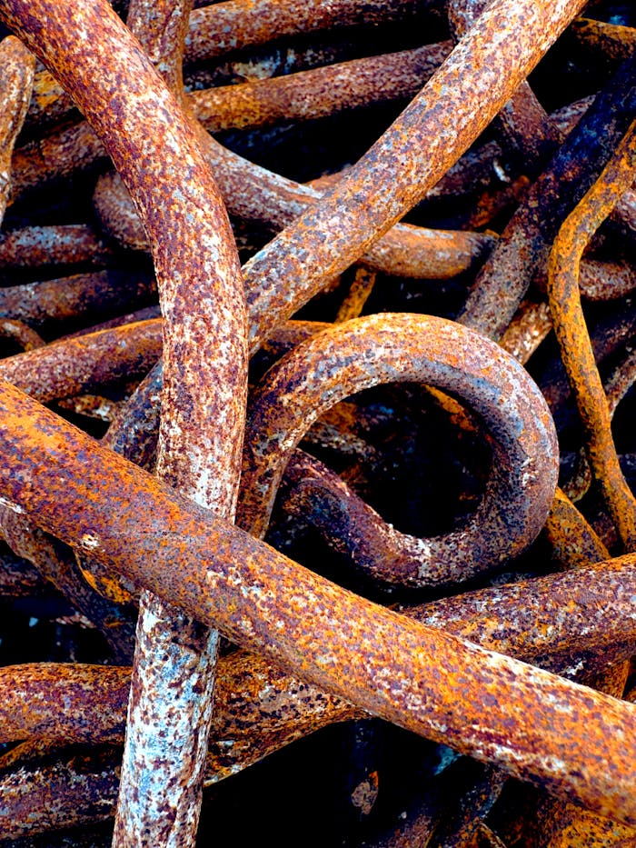 Detailed close-up of intertwined rusted metal chains creating an abstract texture.